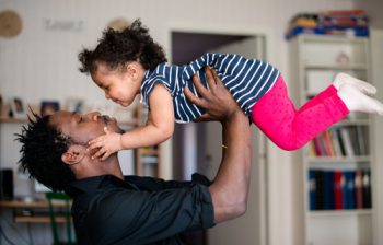 Father tossing his daughter in the air. Learn more about quitting tobacco.